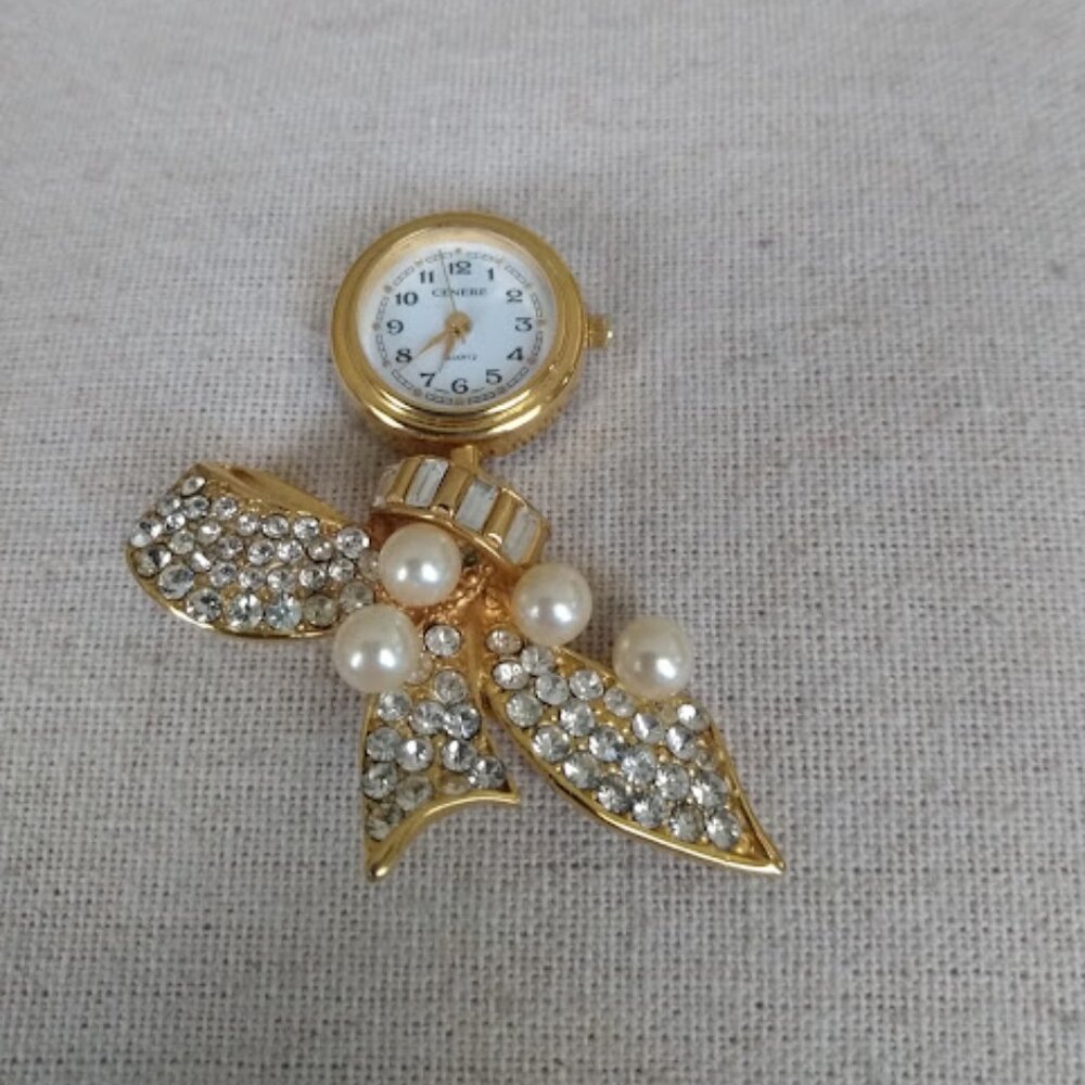 Cenere: Quartz brooch watch with faux pearls and rhinestones.